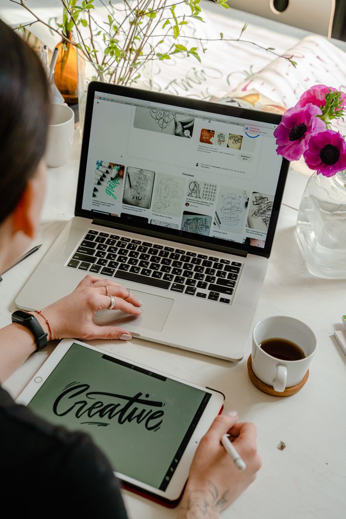 Portfolio Creative work session featuring a woman using a tablet and laptop for design projects.